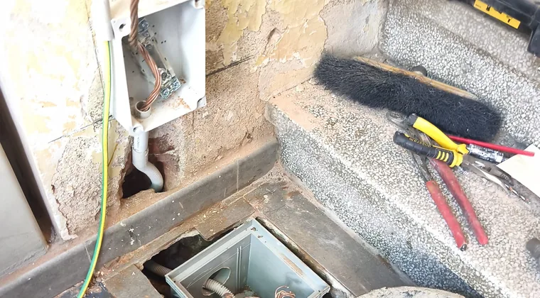 Arqueta de toma de tierra sellada junto a las herramientas del electricista